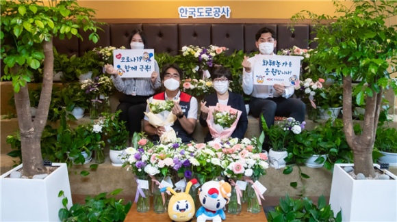 김진숙 한국도로공사 사장(앞줄 오른쪽)과 이지웅 한국도로공사 노조 위원장(왼쪽)이 직원들과 플라워 버킷 챌린지에 동참해 기념촬영을 하고 있다./도로공사